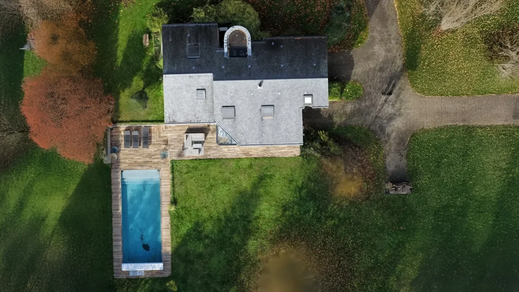 Vue aérienne verticale (orthoprojection) d'une propriété avec piscine et jardin paysager prise par drone.